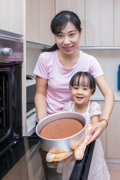 Asian Chinese mother and daughter baking cake together — Stock Photo, Image