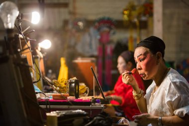 Çin Opera grubu üyesi, sahne arkasında hazırlar