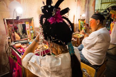 Çin Opera grubu üyesi, sahne arkasında hazırlar