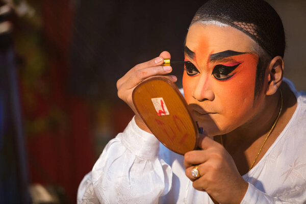 Член Китайской оперы готовится за кулисами
