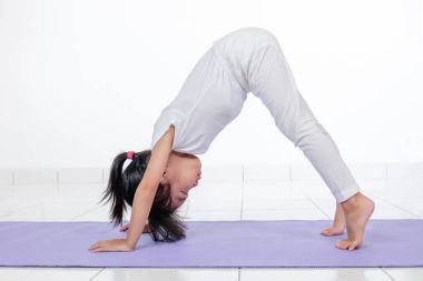 Asyalı Çinli küçük kız pratik yoga teşkil