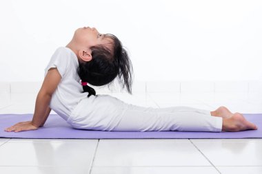 Asyalı Çinli küçük kız pratik yoga teşkil