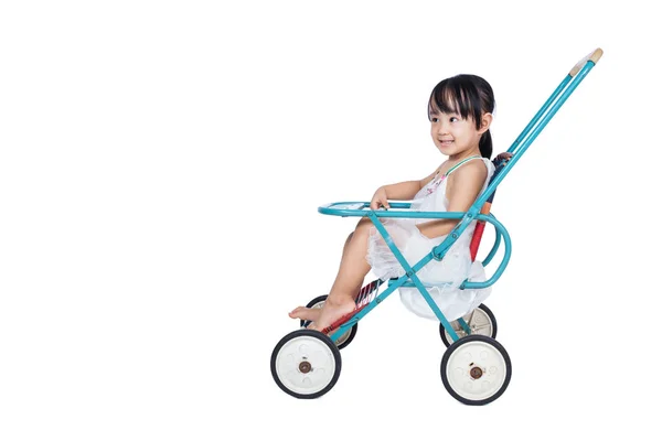 Asiatiska kinesiska liten flicka sitter i en retro barnvagn — Stockfoto