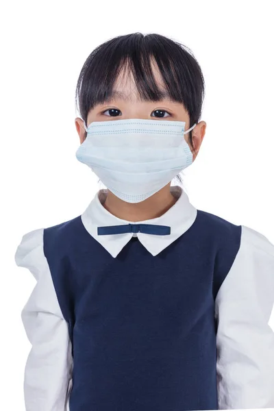 Aasialainen kiinalainen pieni peruskoulun tyttö yllään suojaava ma — kuvapankkivalokuva