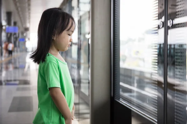 Asian Chinese little girl waiting for transit — Stock Photo, Image