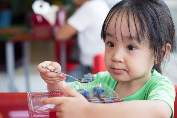 Asiatiska liten kinesisk flicka äter klibbig ris — Stockfoto