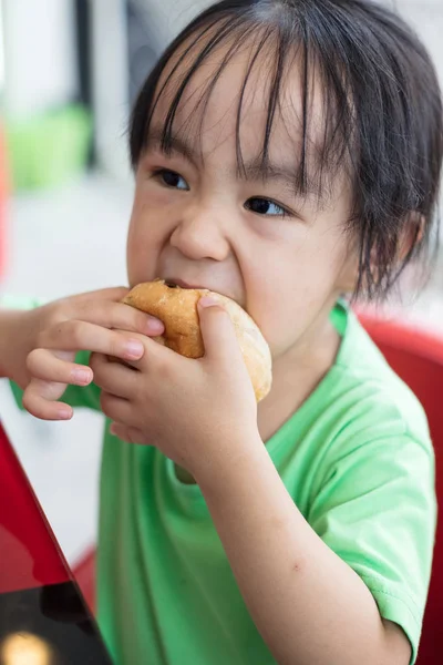 Asian little Chinese girl eating bread — Stock Photo, Image