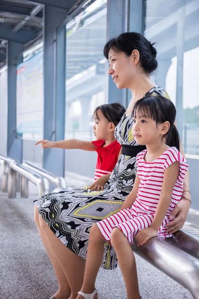 Asian Chinese mother and daughters waiting for a bus