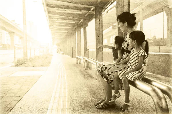 Asiatische chinesische Mutter und Töchter warten auf einen Bus — Stockfoto