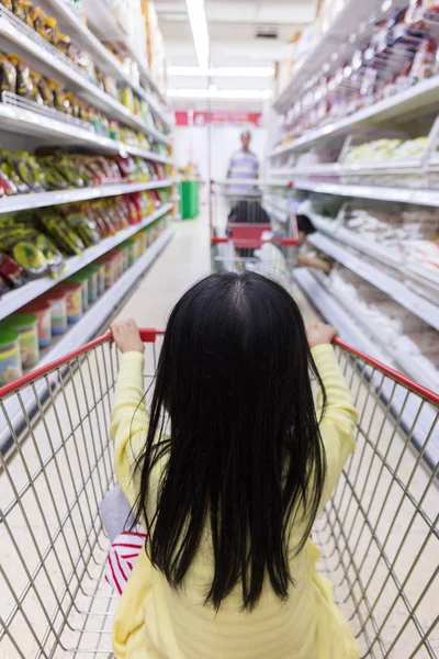 Asian Little Chinese Girl sitting in shopping cart