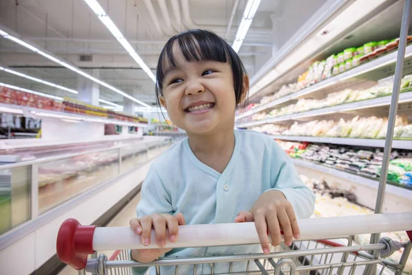 Glücklich asiatische kleine chinesische Mädchen sitzen in Einkaufswagen — Stockfoto