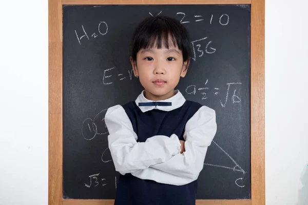 Asian Chinese little girl standing in front of blackboard — Stock Photo, Image