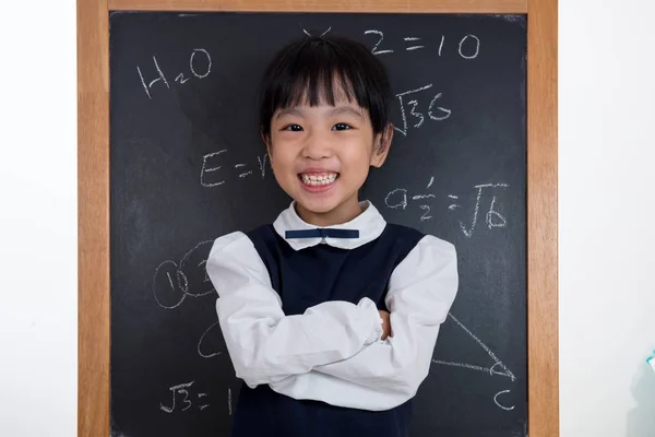Asian Chinese little girl standing in front of blackboard — Stock Photo, Image