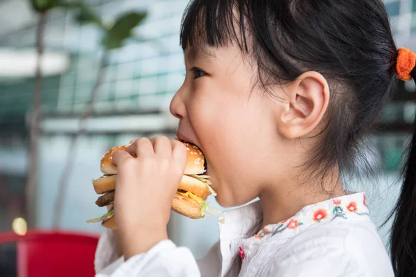 Asiatiska kinesiska liten flicka äta Burger — Stockfoto