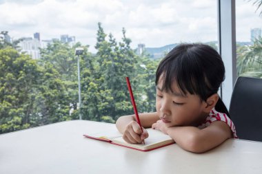 Asyalı küçük Çinli kız ev ödevi yazma