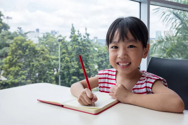 Asian little Chinese girl writing homework