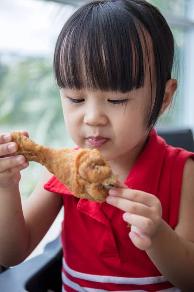 Asiatiska kinesiska lilla flicka äter stekt kyckling — Stockfoto