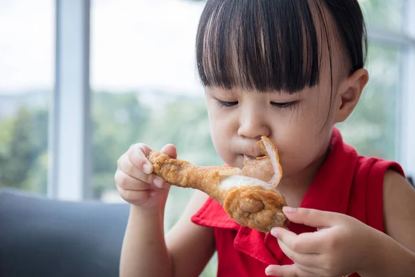 Asian Chinese little girl eating fried chicken — Stock Photo, Image