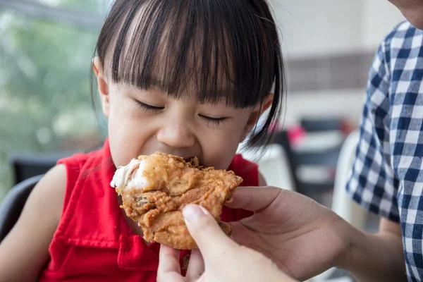 Asian Chinese mother and daughter eating fried chicken — Stock Photo, Image