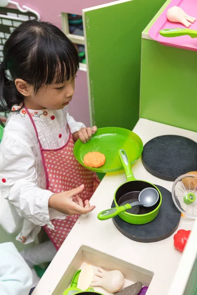Asian Chinese little girl role-playing at kitchen — Stock Photo, Image
