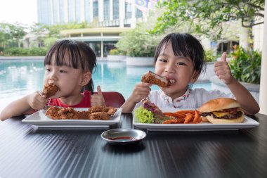 Asyalı küçük Çinli kızlar yemek Burger ve kızarmış tavuk