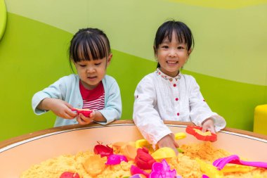 Asyalı Çinli kız kardeşim Kinetik kum oynarken