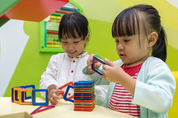 Asiatiska kinesiska små flickor spela färgglada magnet plast block — Stockfoto