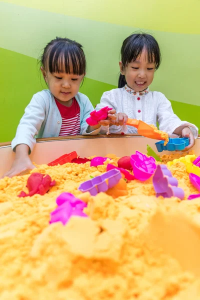 Asyalı Çinli kız kardeşim Kinetik kum oynarken