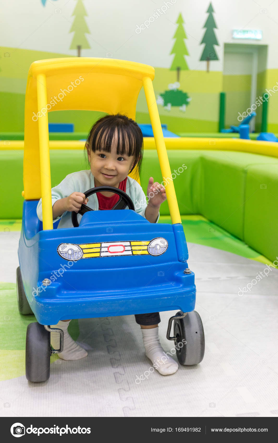 little girl driving toy car