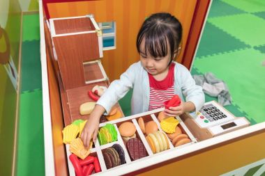 Asyalı Çinli küçük kız Burger dükkanında rol yapma oyunu