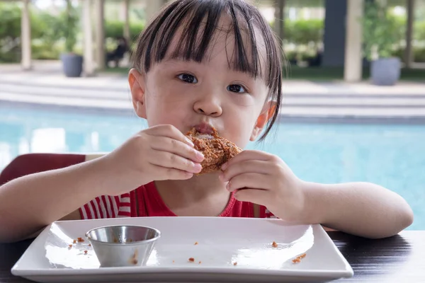 Asiatiska liten kinesisk flicka äter stekt kyckling — Stockfoto