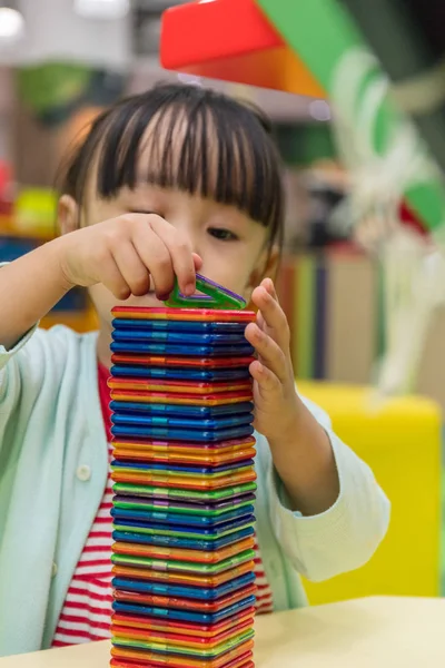 Asiática china niña jugando colorido imán plástico bloques — Foto de Stock