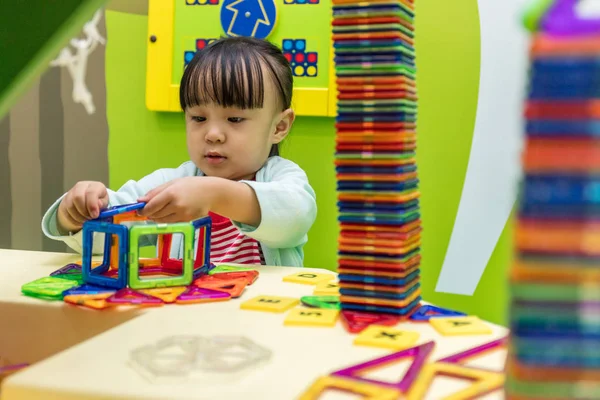 Asiática china niña jugando colorido imán plástico bloques — Foto de Stock