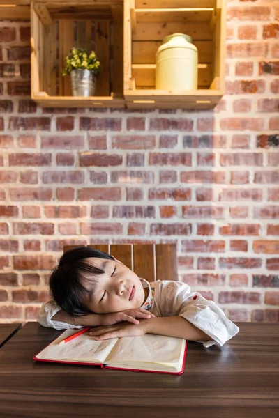 Asiatisch chinesisch klein mädchen schlafen auf tisch während tun homeaufgaben — Stockfoto