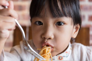 Asyalı Çinli küçük kız spagetti bolognese yeme