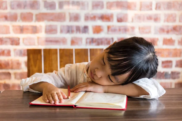Asiatisch chinesisch klein mädchen schlafen auf tisch während tun homeaufgaben — Stockfoto