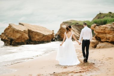 Genç çift damat ile gelini kumlu bir plaj üzerinde