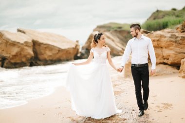 Genç çift damat ile gelini kumlu bir plaj üzerinde