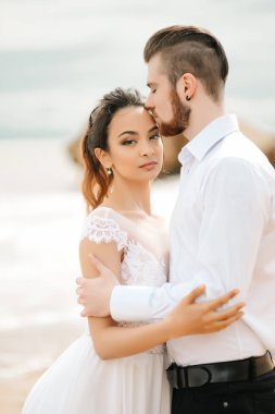 Genç çift damat ile gelini kumlu bir plaj üzerinde