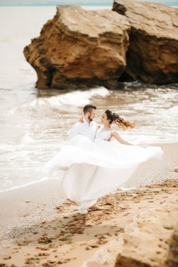 Genç çift damat ile gelini kumlu bir plaj üzerinde