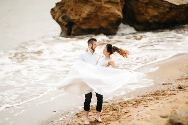 Genç çift damat ile gelini kumlu bir plaj üzerinde