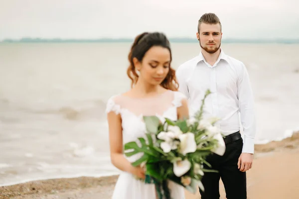 Novio joven pareja con la novia en una playa de arena — Foto de Stock