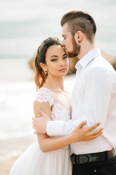 Noivo de par jovem com a noiva em uma praia arenosa — Fotografia de Stock