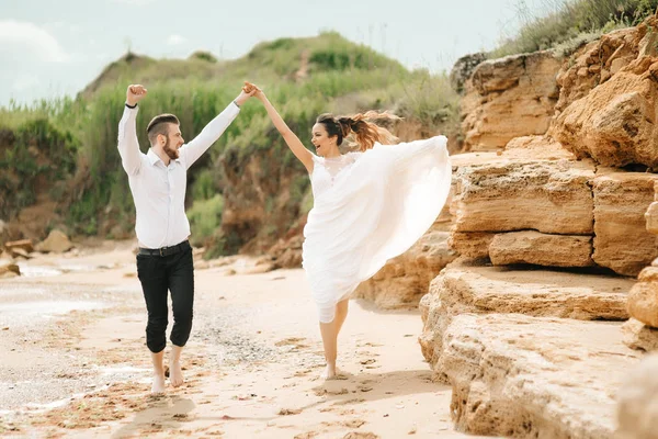 Fiatal pár vőlegény, a menyasszony a homokos tengerparton — Stock Fotó