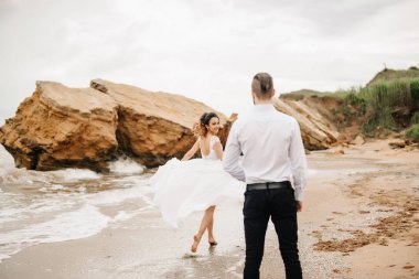 Genç çift damat ile gelini kumlu bir plaj üzerinde