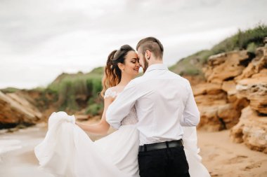 Genç çift damat ile gelini kumlu bir plaj üzerinde