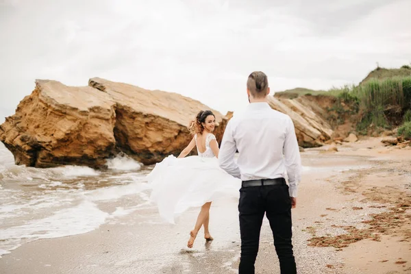 Jeune couple marié avec la mariée sur une plage de sable fin — Photo