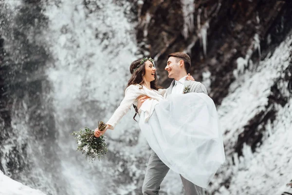 Bride and groom on the mountain waterfall — Stock Photo, Image