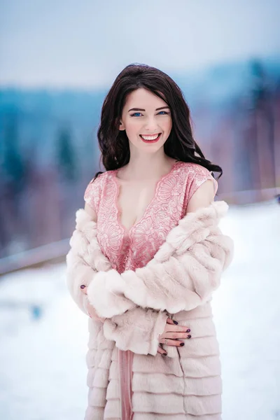 Brud med kastanj hår, blå bakgrund av berget vinter — Stockfoto