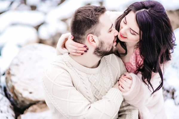 Pareja joven en un paseo por las montañas nevadas — Foto de Stock